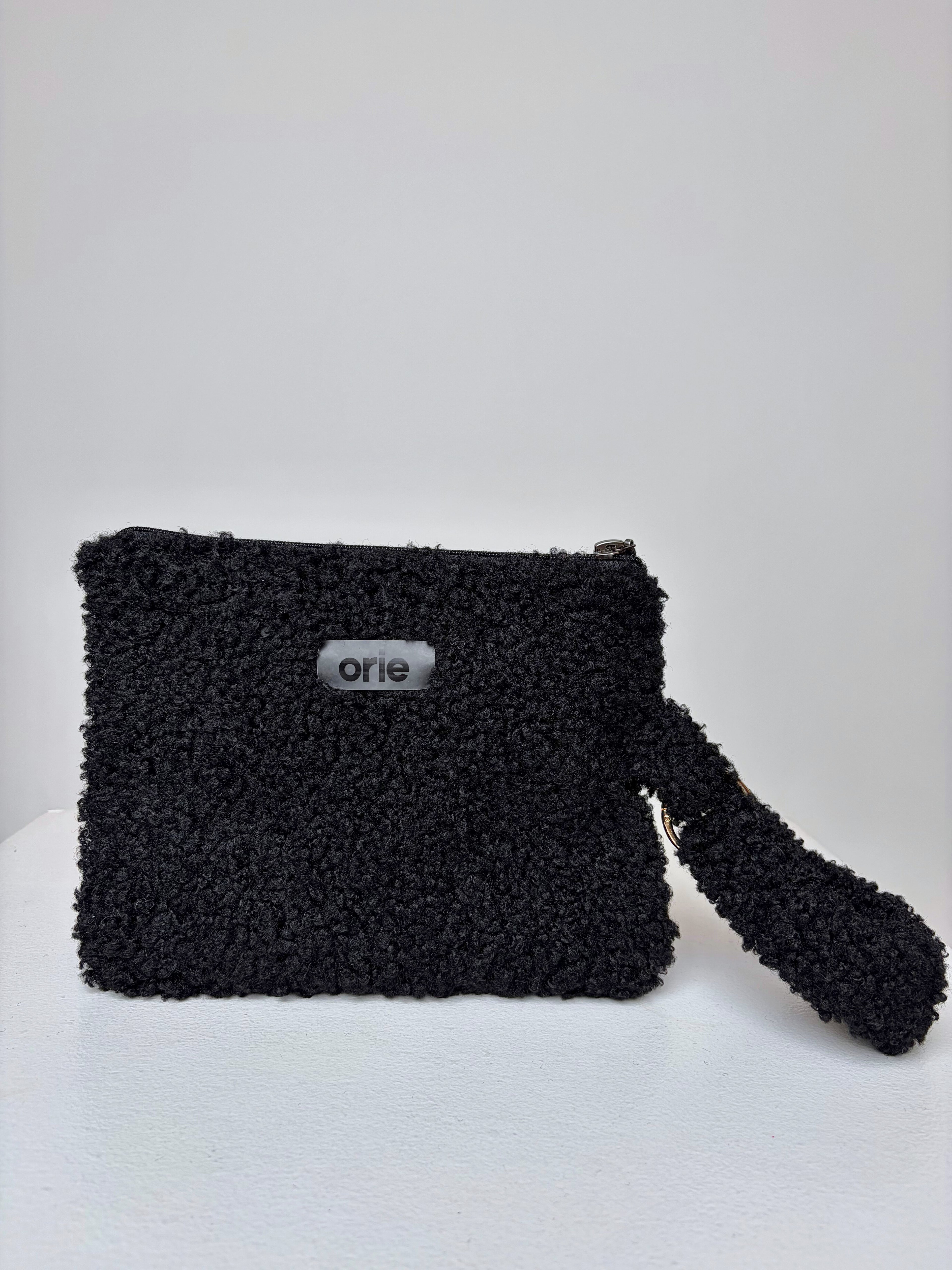 Black teddy pouch with 'orie' branding on a white background